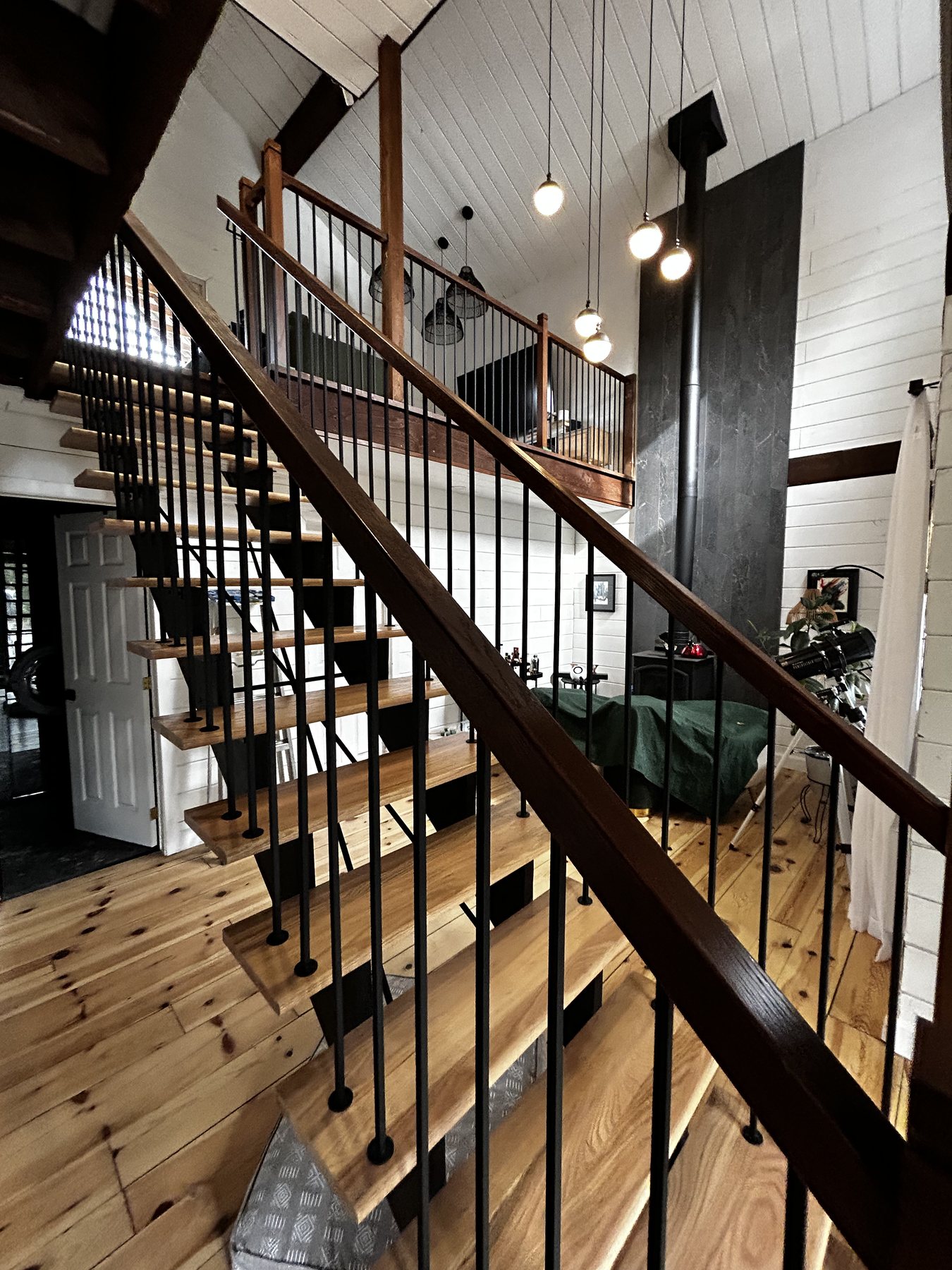 Escalier sur mesure en acier et bois dans un séjour à plafond cathédrale